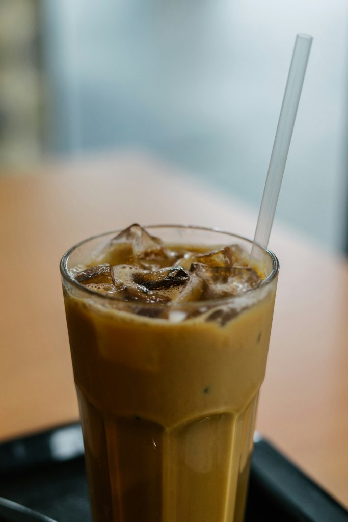 Ice coffee in a glass with a strew and ice